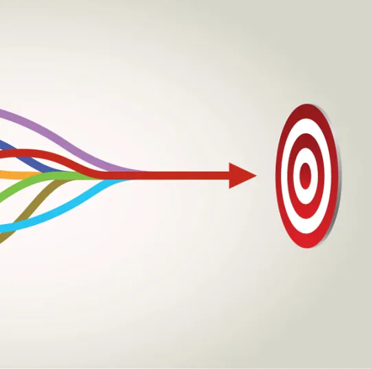 A group of colorful lines in purple, blue, green, yellow, orange, and red, all pointing towards a circular target with a red border and a white center, featuring a smaller red circle in the middle. An arrow leads directly from the colorful lines to the target, emphasizing focus and direction.